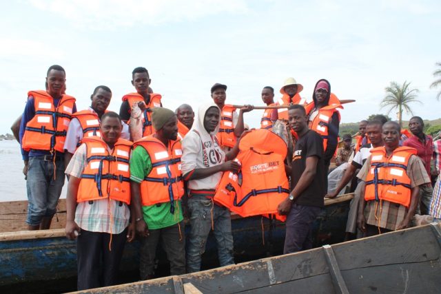 John Nanyumba (in black) handing over the life jackets to the fishermen donated by forteBet